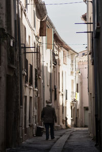 Rear view full length of man walking in alley