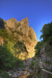 Scenic view of rocky mountains against clear blue sky