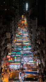 High angle view of illuminated street amidst buildings at night