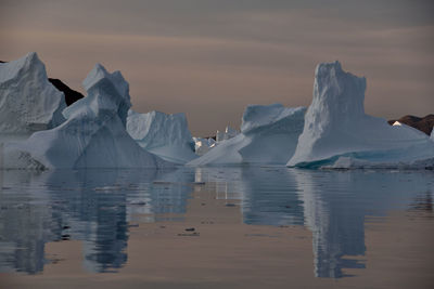Scenic view of iceberg shapes and reflectins in mirror-like sea in greenland scoresby sound