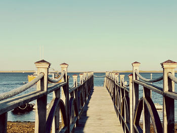 Pier over sea against clear sky