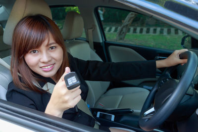 Portrait of smiling woman sitting in car