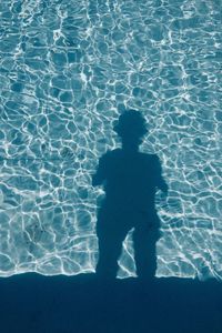 High angle view of silhouette person standing in swimming pool