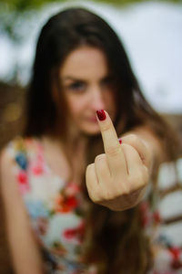 Close-up of woman showing obscene gesture