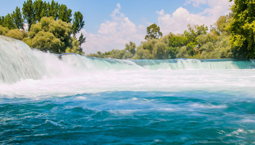 Scenic view of waterfall against sky