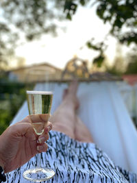 Midsection of person holding beer glass