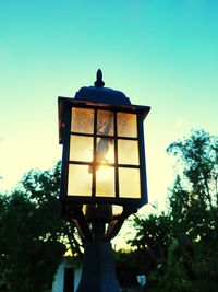 Low angle view of illuminated street light against sky