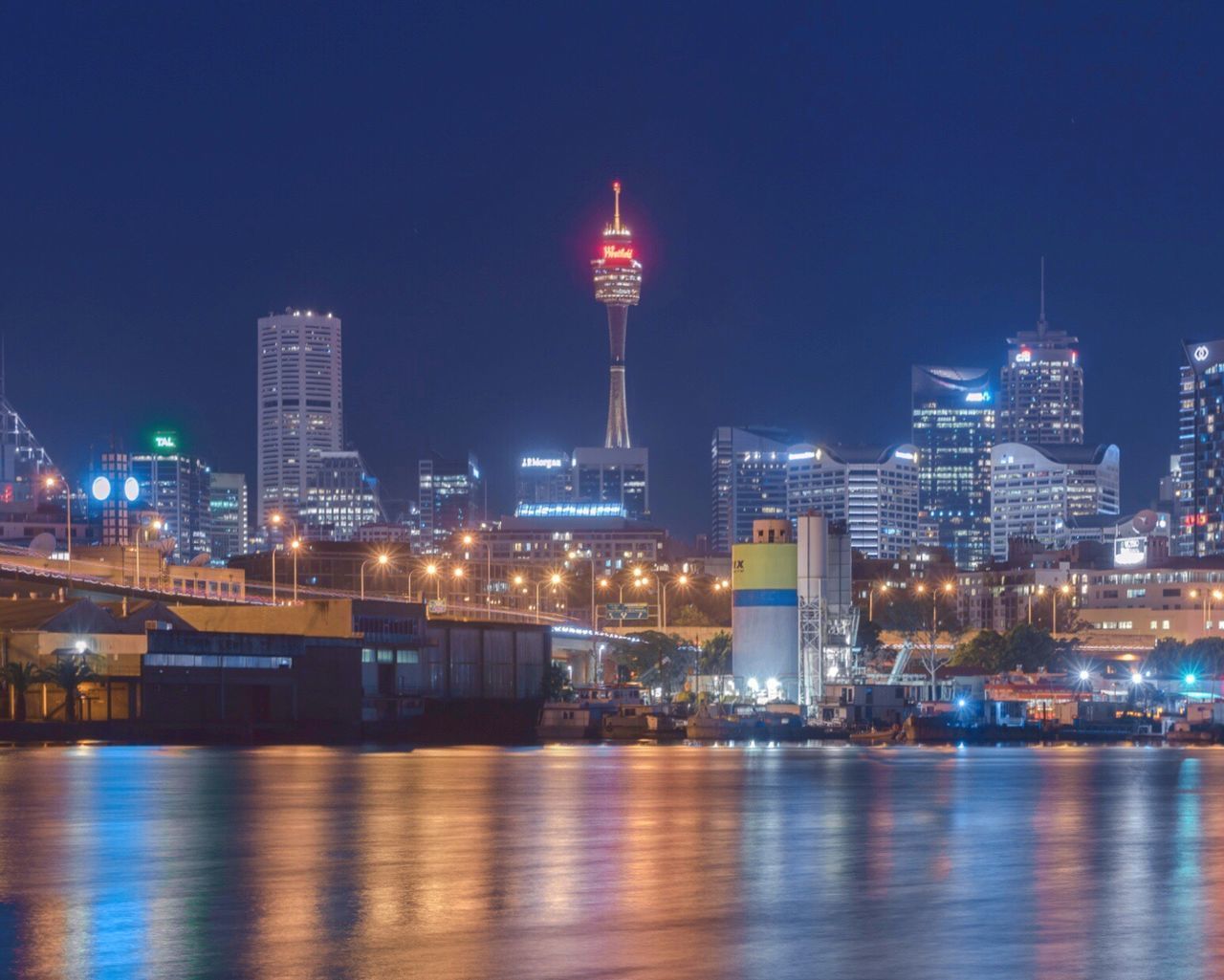 VIEW OF ILLUMINATED CITY AT WATERFRONT