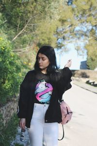 Full length of woman standing against trees