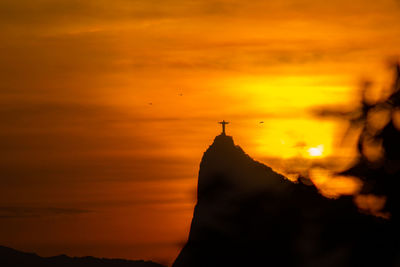 Silhouette of temple building against sky during sunset