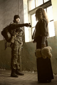 Young woman standing against wall