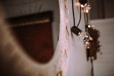Close-up of light bulb hanging on wall