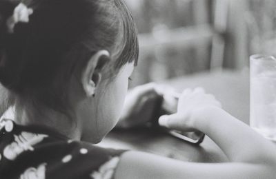 Close-up of girl using mobile phone at home