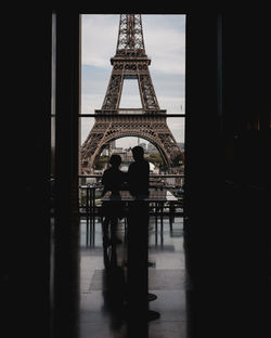 Silhouette of people in front of tower