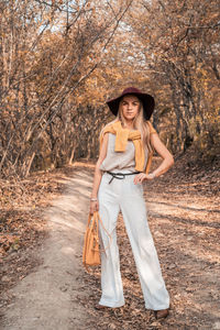 Portrait of a smiling young woman standing against plants