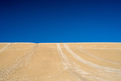 Scenic view of desert against clear blue sky