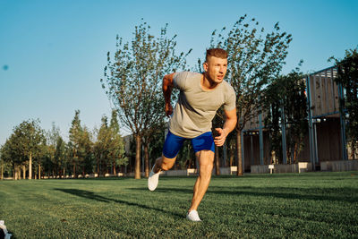 Portrait of young man exercising on field