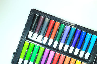 High angle view of multi colored felt tip pens against white background