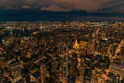 Aerial view of illuminated cityscape against sky at night