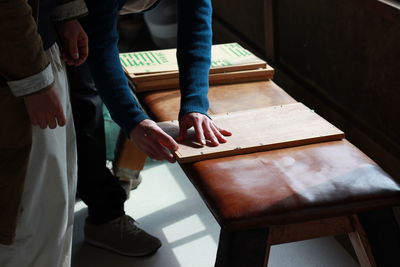 Friends working on wood in room