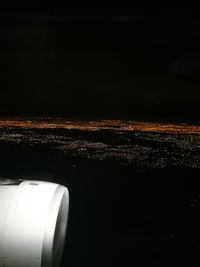 Close-up of illuminated airplane against sky at night