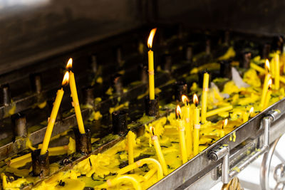 High angle view of yellow burning candles