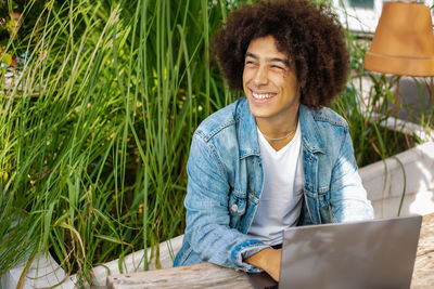 Portrait of young woman using laptop at park