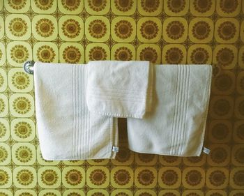 Napkin and towels hanging on rail mounted to wall