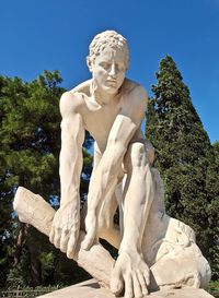 Low angle view of statue against blue sky