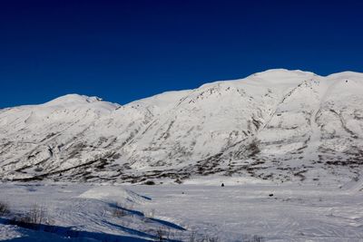 Scenic view of snowcapped mountains against clear blue sky