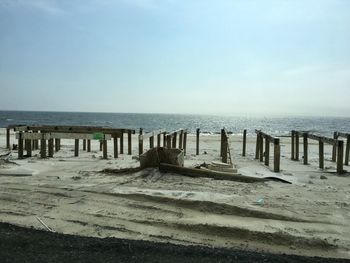 Wooden posts on beach against clear sky