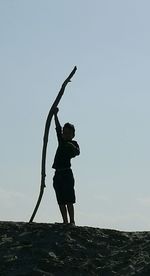 Full length of silhouette man standing on beach against sky