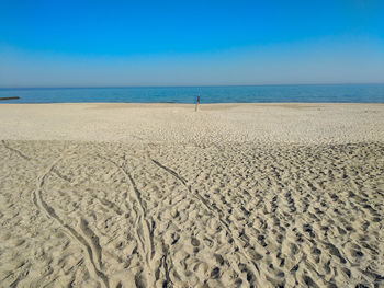 Scenic view of beach against clear blue sky