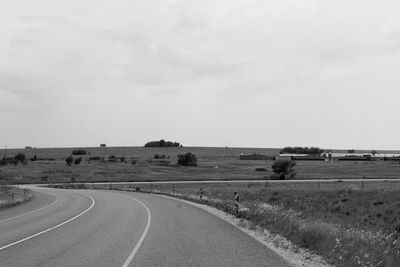 Empty road on field against sky