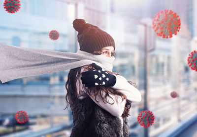 Portrait of woman with hat standing in winter