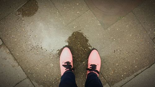 Low section of man standing on wet street