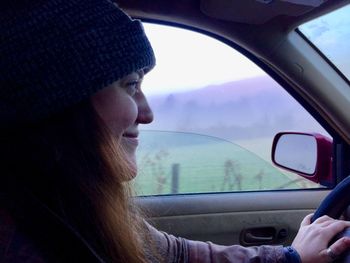 Portrait of woman seen through car windshield