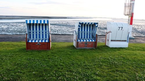 Chairs on beach against sky