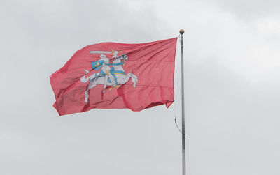 Low angle view of red flag against sky