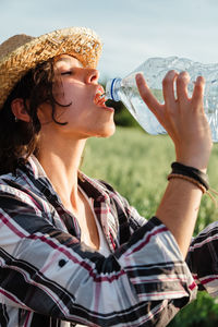 Midsection of man drinking glass bottle