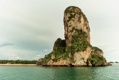 Rock formation by sea against sky