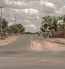 Empty road against cloudy sky