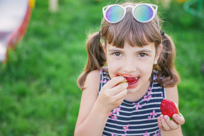 Portrait of cute girl eating strawberry