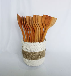 Close-up of bread in basket on table against white background
