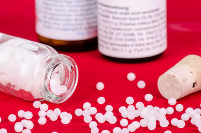 Close-up of medicines spilling from bottle on table