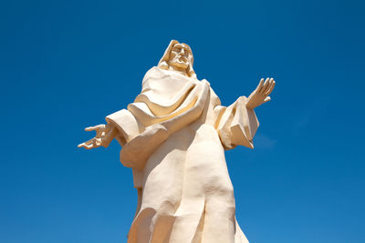 Low angle view of statue against blue sky