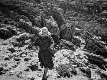 Rear view of woman standing on rock