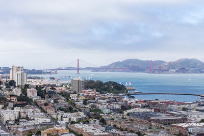 High angle view of city by sea against sky