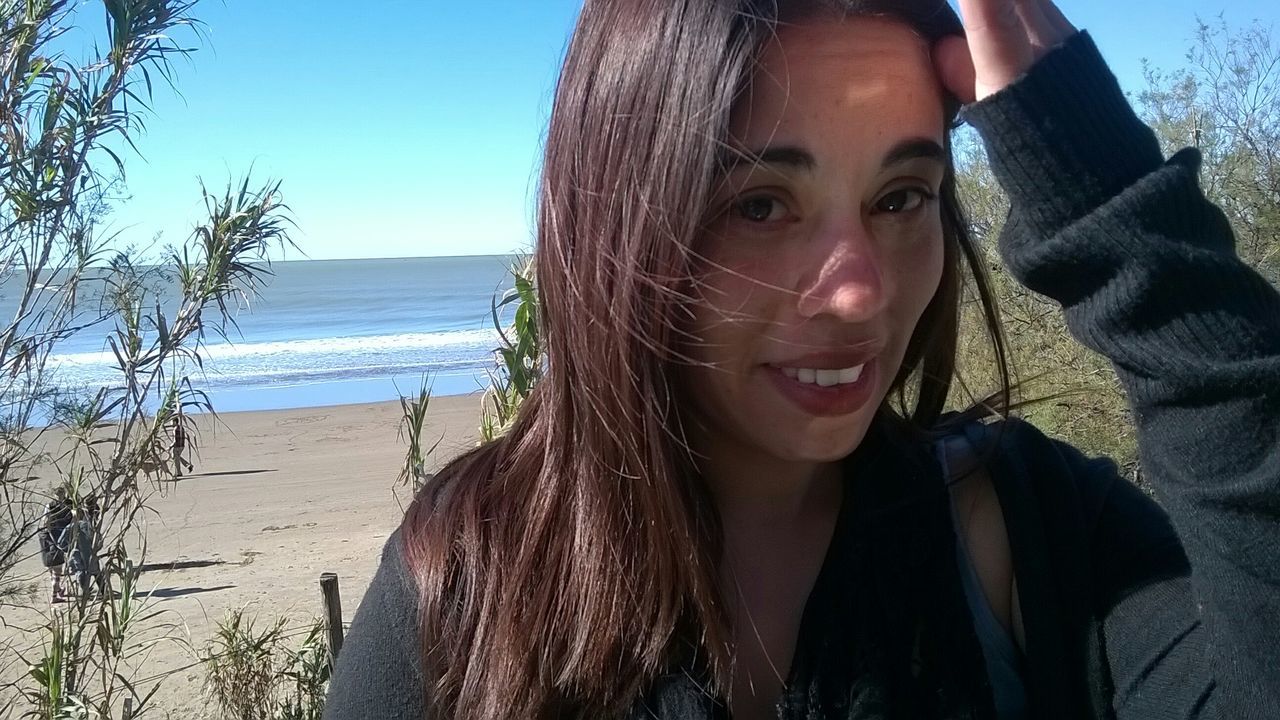 sea, beach, young adult, lifestyles, leisure activity, young women, horizon over water, water, sunlight, clear sky, shore, headshot, person, vacations, long hair, sky, portrait, nature