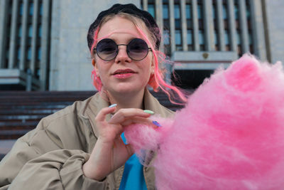 Woman eating cotton candy outdoors